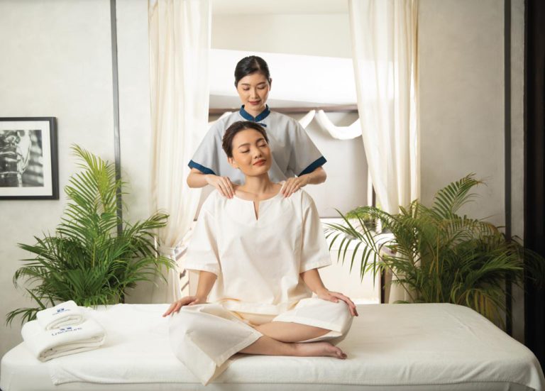 Spa Therapist Massages The Shoulders Of Woman In Thai Massage Uniform