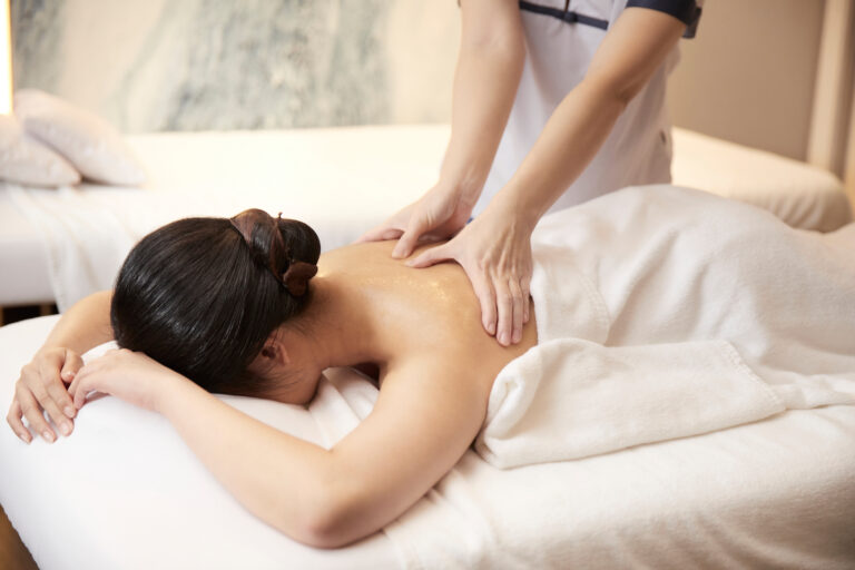 A woman receiving a relaxing back massage at a spa